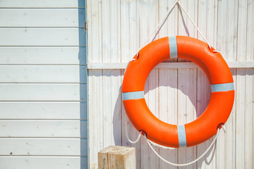 red lifebuoy on a white wooden wall. Background, copyspace