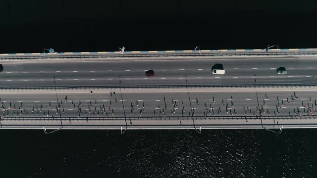 4K Aerial drone fooage. Marathon running on the bridge. Horizontal movement dolly shot top view