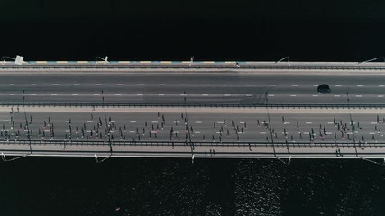 4K Aerial drone fooage. Slow motion Marathon running on the bridge. Horizontal dolly shot top view