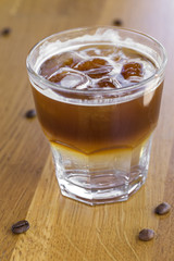 Cold coffee with ice cubes and coffee beans
