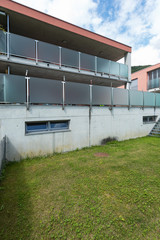 Red building exterior with large garden and glass parapet