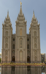 Salt Lake Temple reflecting in the pond below while early summer weddings are being celebrated. The Church of Jesus Christ of Latter-day Saints, Salt Lake City, Utah, USA.