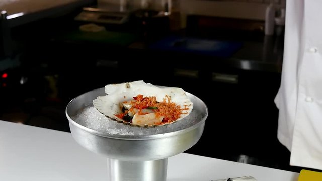 The chef prepares a sea salad of scallops with various spices in the restaurant's kitchen. Slow motion shot. Recipes for cooking.