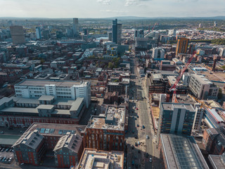 Fototapeta na wymiar Aerial city centre drone above buildings british manchester skyline summer blue sky ancoats northern quarter