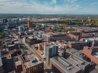 Fototapeta na wymiar Aerial city centre drone above buildings british manchester skyline summer blue sky ancoats northern quarter