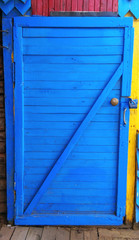wooden door of blue color closed on the lock