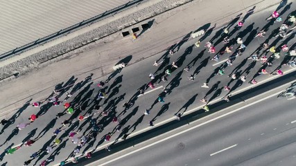 4K Aerial drone fooage. Marathon running on street. Camera rotate. Top view