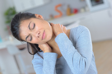 young woman feeling exhausted and suffering from neck pain
