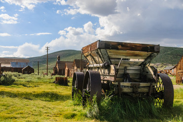 Naklejka premium An old wooden wagon with rusty iron wheels in the the American Ghost town of Bodie.