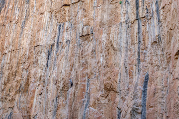 Male climber hanging in the middle of a cliff