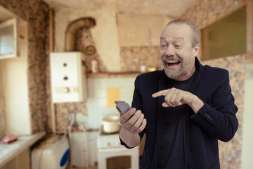 Cheerful, bearded, white man is talking on phone.