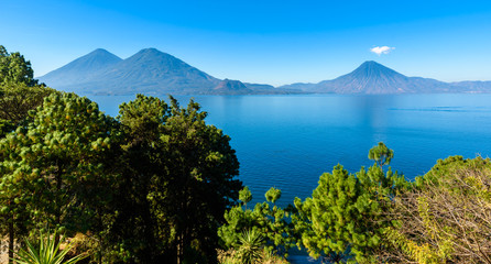 View from Lake Atitlan in the early morning, blue skys and clear water, beautiful magic lake with volcanos and indigenous people in the highland of Guatemala 