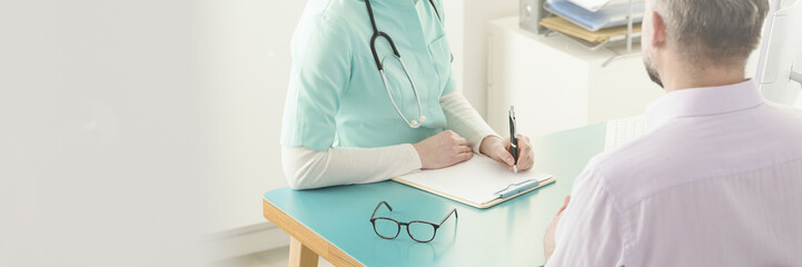 Doctor writing down patient's information