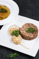 Complex dinner. Buckwheat porridge with dietary meat on a white plate is tenderly served
