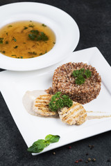 Complex dinner. Buckwheat porridge with dietary meat on a white plate is tenderly served