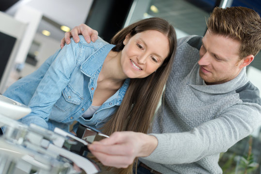young couple holding credit card together