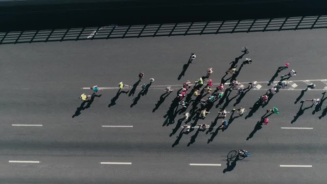 Marathon running on street. Following Group of athletes slow motion. Top view