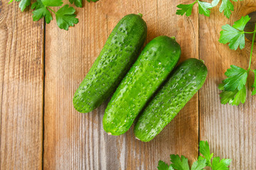 Fresh green homemade cucumber with parsley on an old wooden table.