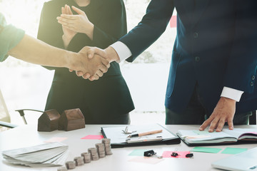 real estate agent shaking hands to his client after signing contract agreement in office,concept...