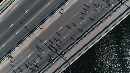 4K Aerial drone fooage. Marathon running on the bridge. Camera top view