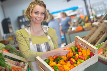 Clerk holding crate of peppers