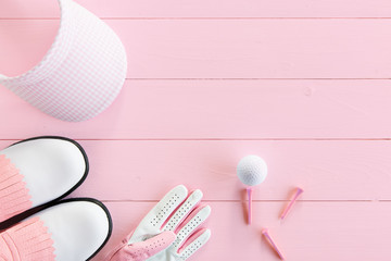 Golfequipment für Damen auf Holzunterlage in pink von oben
