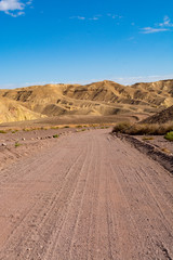Dirt road in desert Negev, Israel,  transport infrastructure in desert, scenic mountains route from Eilat to north of Israel