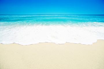 Fototapeta na wymiar Beautiful Tropical beach with Soft wave of blue ocean, white sand and transparent sky. Summer travel holiday background concept. Sea panorama.
