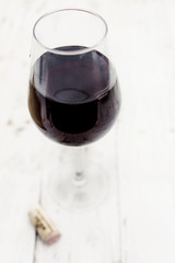  A glass of red wine on vintage white wooden background, copyspsce. Wine tasting concept.