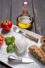 Traditional italian food - white ball mozzarella buffalo Italian soft cheese with cheese knife, tomato, basil, olive oil
