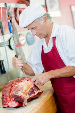 Skilled butcher preparing cuts of beef