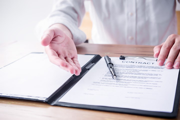 Close up business man reaching out sheet with contract agreement proposing to sign.Full and accurate details, individual who owns the business sign personally,director of the company, solicitor.