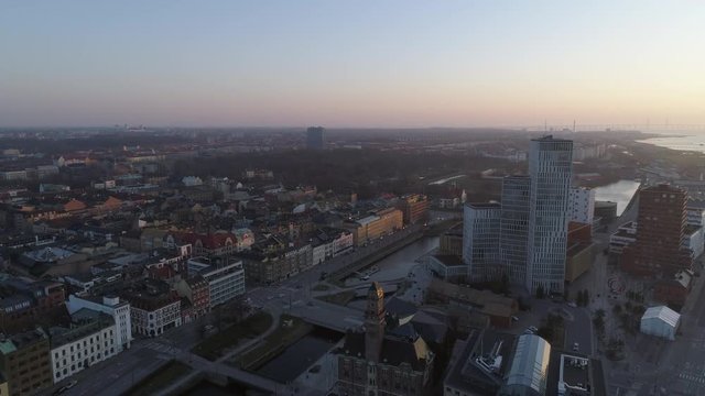 Aerial view of Malmö cityscape at sunset. Drone shot flying over the city and towards modern skyscraper building