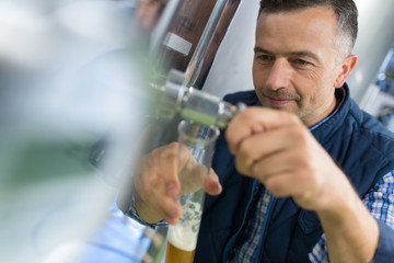 manufacturer holding beer glass at brewery