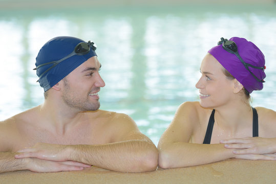 young couple of swimmers inside swimming pool