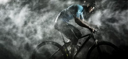 Foto auf Acrylglas Cyclist cycling on mountain bike with rainy ,foggy on black background. © candyhalls