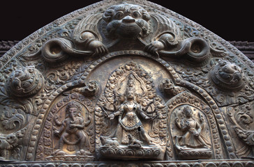 Tympanum with ancient wooden bas-relief on the Palace at Durbar Square in Patan, Nepal