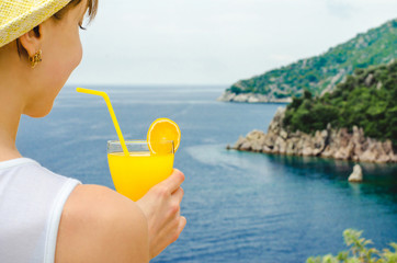 Diet. Healthy eating. Silhouette woman drinks lemonade drink in glass background sea wild nature outdoor beach cocktail. Fresh detox vegetable orange juice. Healthy lifestyle, 