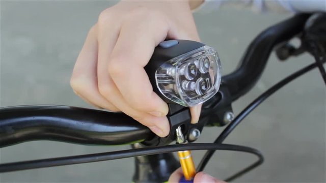 install a flashlight on a bike,hands set on a rider bicycle lantern