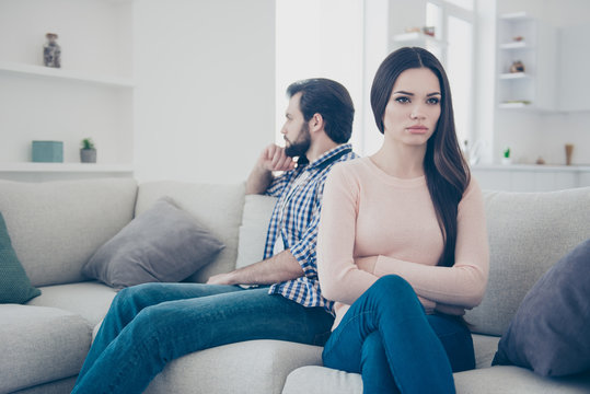 Portrait of sad couple having conflict upset girl sitting with crossed folded hands ignore her boyfriend after scandal they do not speak with each other having distrust disrespect
