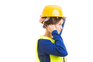 Young female architect tucking hair under helmet.