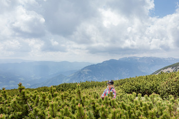 Young girl enjoying smell of pine trees in mountain scenery on Schneeberg in Lower Austria