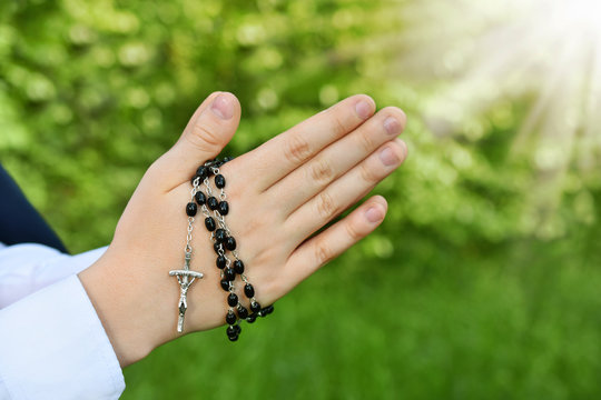 First Holy Communion With Rosary Around Praying Boy Hands