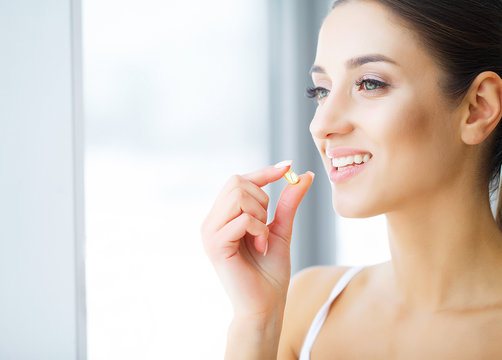 Dental care. Beautiful young woman eating chewing gum, smiling.