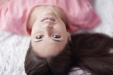 close up.portrait of young woman lying on white carpet in living room