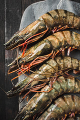 Raw prawns in shells on a stone board, top view.