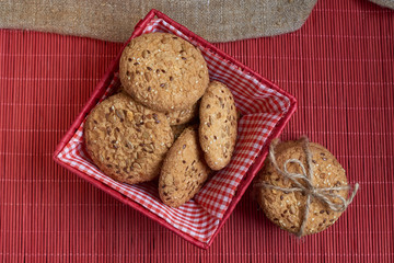 Savory cookies sprinkled with sesame seeds, sunflower on table and burlap background