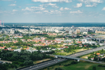 Fototapeta na wymiar Aerial picture of city with houses and gardens, crossroads and roads, houses, buildings, parks and parking lots, bridges. Airplane drone shot.