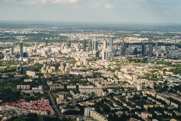Aerial picture of city with houses and gardens, crossroads and roads, houses, buildings, parks and parking lots, bridges. Airplane drone shot.