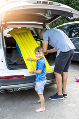 Father and son are packing car for vacation